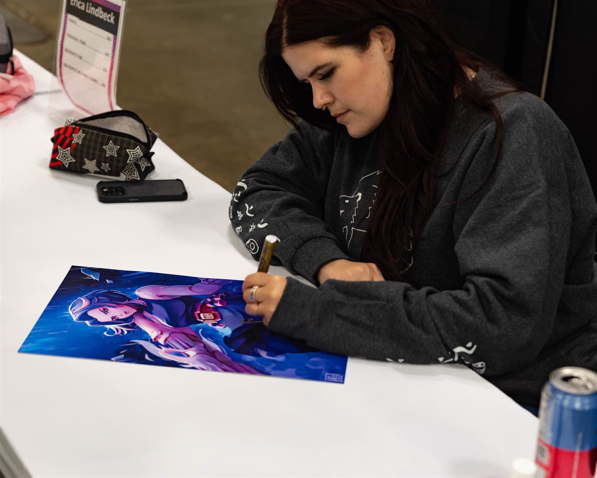 Erica Lindbeck signing an illustrated print at Matsuricon.