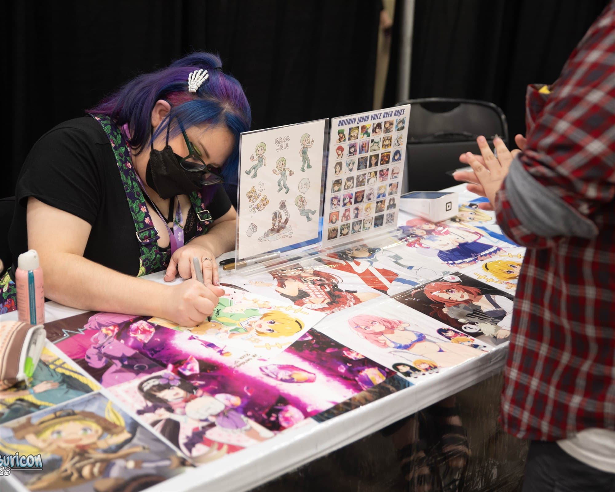 Brianna Knickerbocker signing a print for an attendee at Matsuricon.