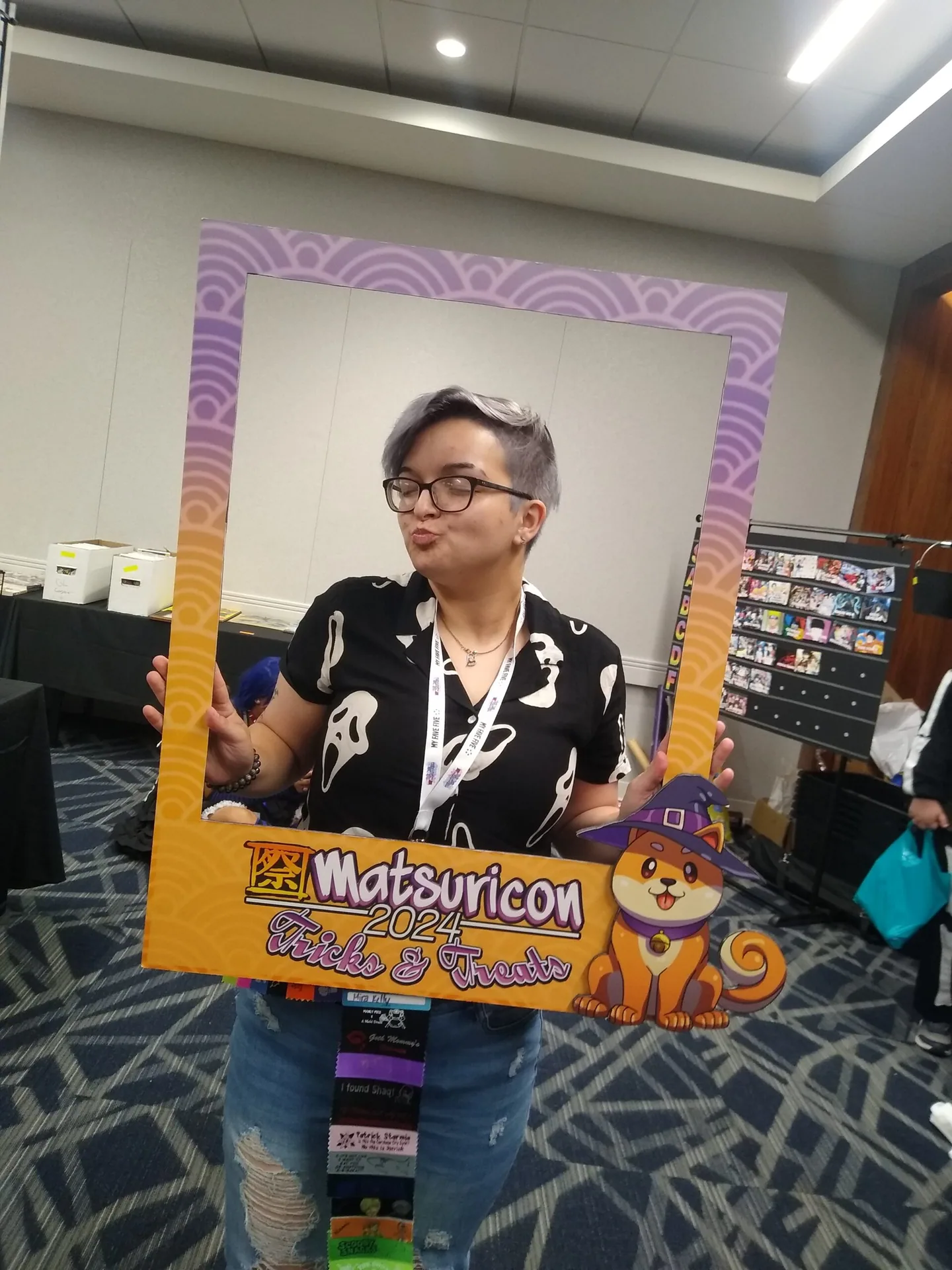 A Matsuricon team member posing with the 2024 Tricks and Treats photo frame