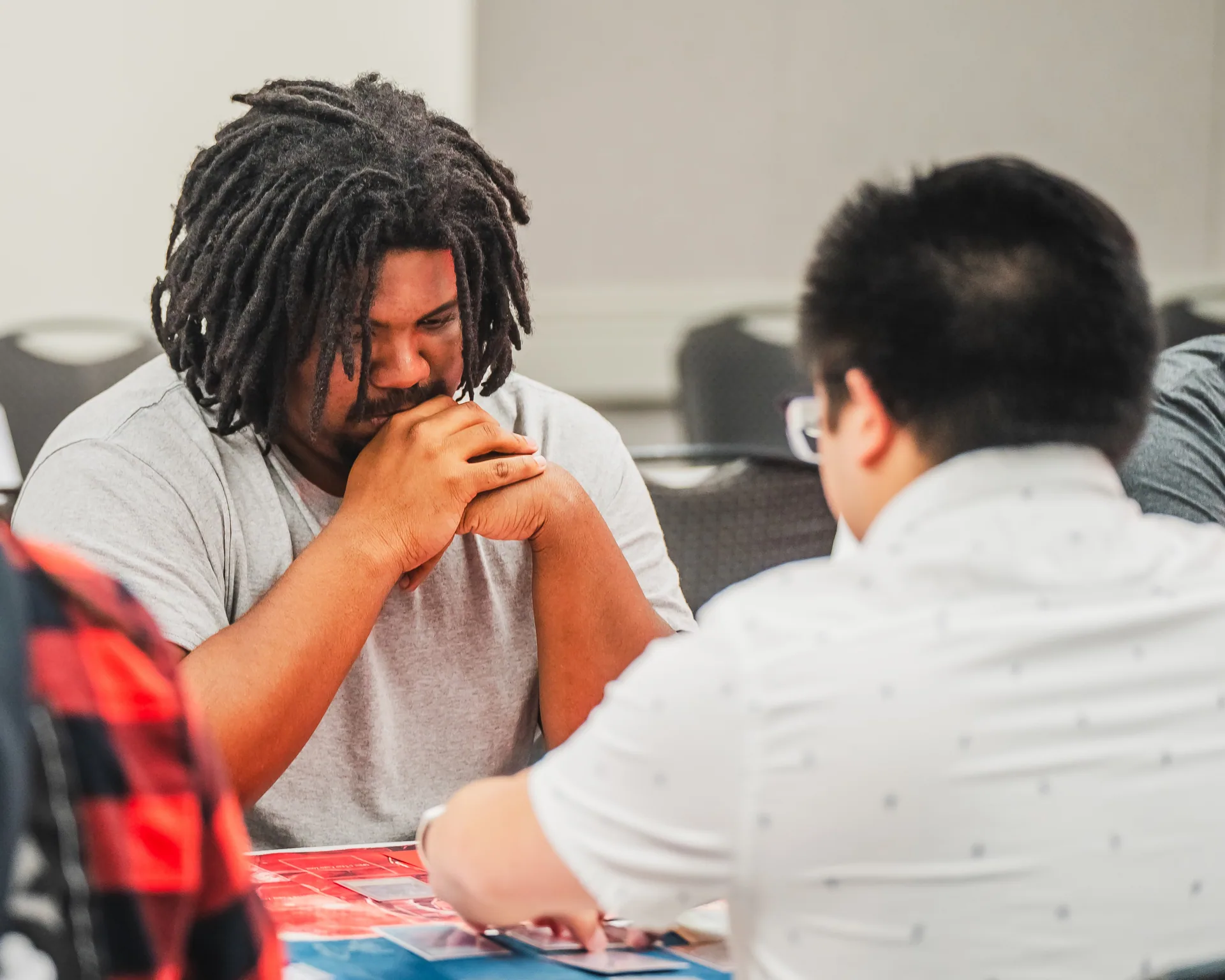A focused card game player studies the table during a match at Matsuricon.